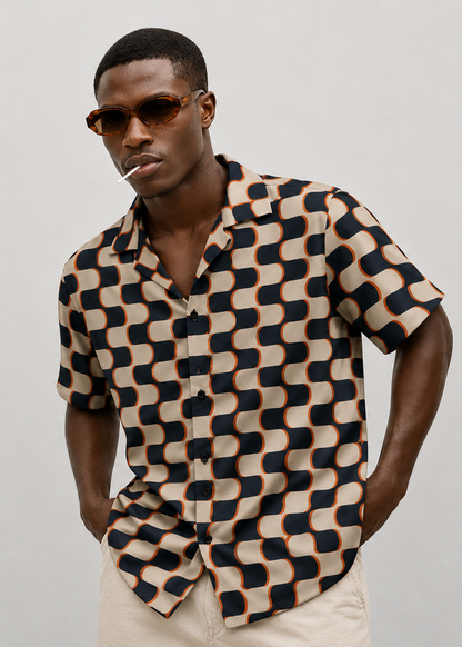 Man wearing a patterned shirt and sunglasses against a plain background