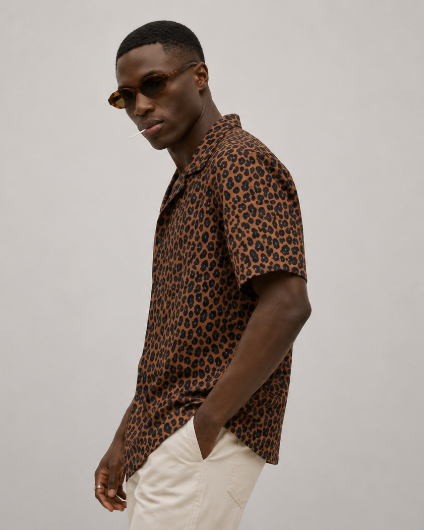 Man wearing a leopard print shirt and sunglasses on a plain background