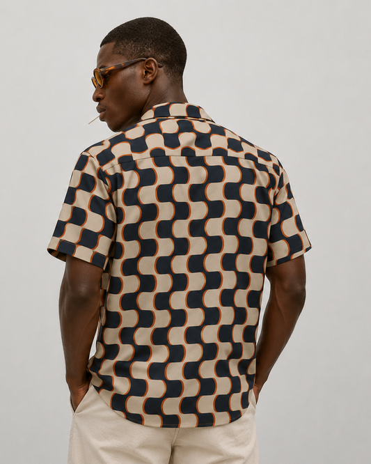 Man wearing a patterned shirt and glasses on a plain background
