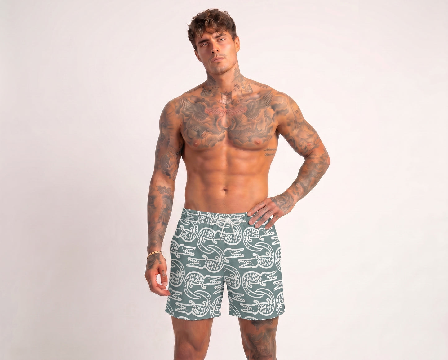 Man wearing green swim shorts with a pattern on a white background