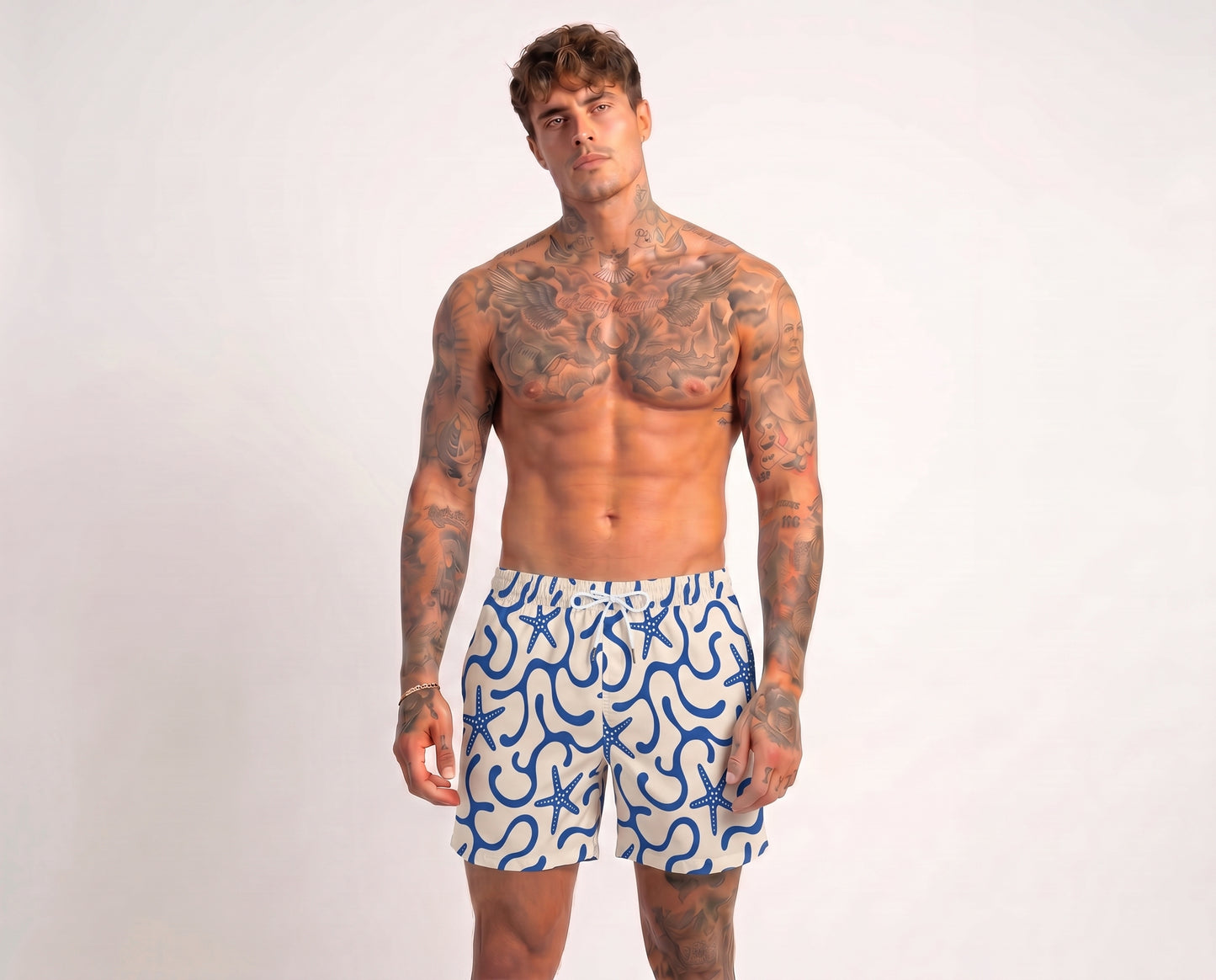 Man wearing blue and white patterned swim shorts on a plain background
