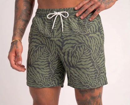 Green patterned shorts worn by a person on a white background