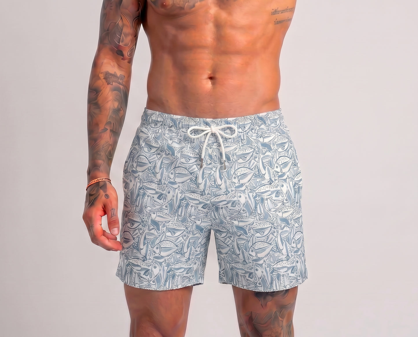 Man wearing patterned swim shorts on a plain background