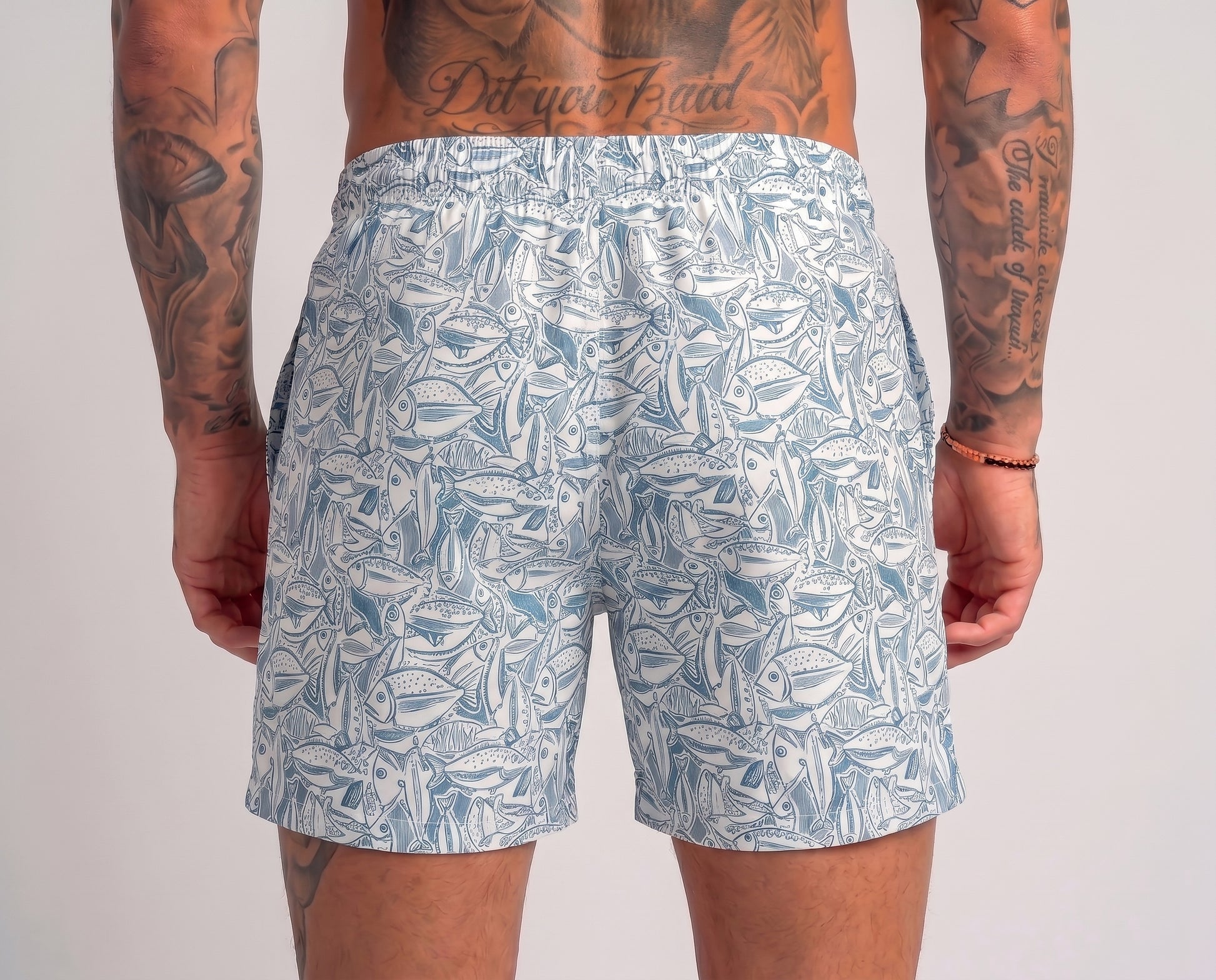 Person wearing blue leaf-patterned shorts on a plain background