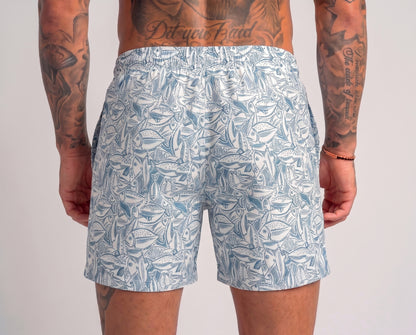Person wearing blue leaf-patterned shorts on a plain background