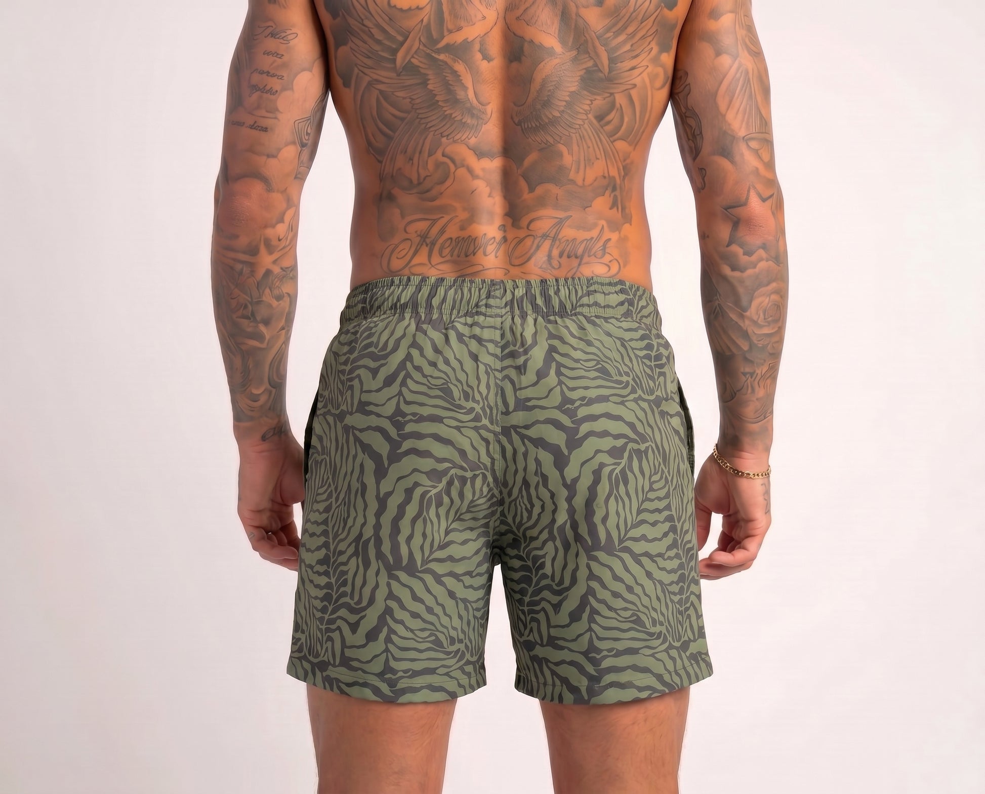 Person wearing green patterned shorts on a plain background